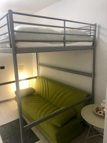 Etagenbett mit grünem Sofa in einem Zimmer in der Unterkunft Hamlet appartment in Neapel