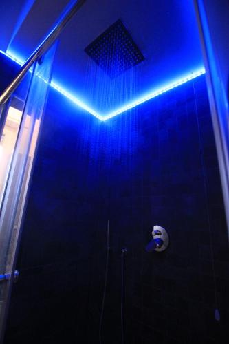 una luz azul en el baño con ducha en Il Rifugio degli Artisti en Varese