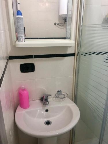 ein Badezimmer mit einem Waschbecken und einer Dusche mit einer rosa Kerze in der Unterkunft Hamlet appartment in Neapel