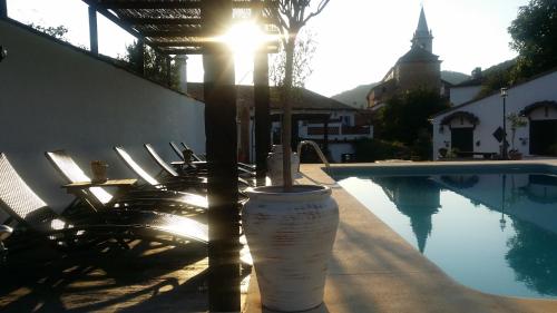 a drink sitting on a table next to a swimming pool at Casona Del Duende in Alájar