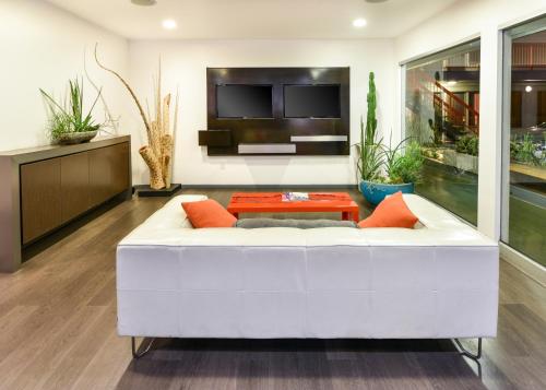 a living room with a white couch and a table at The Tangerine - a Burbank Hotel in Burbank