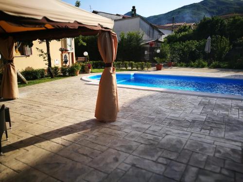 ein Regenschirm auf einer Terrasse neben einem Pool in der Unterkunft La Residenza del Marchesato in Marano Marchesato