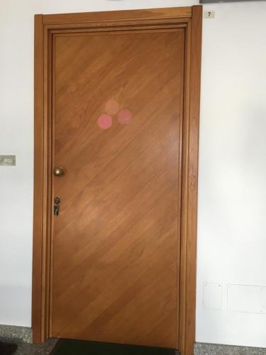 a wooden door with two pink dots on it at La mansarda di Orni in Ivrea