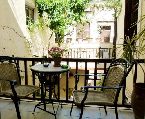 a patio with two chairs and a table on a balcony at Madonna Studios in Chania Town