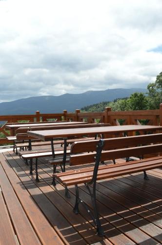 a row of benches sitting on top of a wooden deck at Uroczysko starych sztolni in Szklarska Poręba