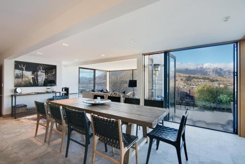 a dining room with a wooden table and chairs at Panorama House by Sotheby's Luxury Rental Homes in Queenstown