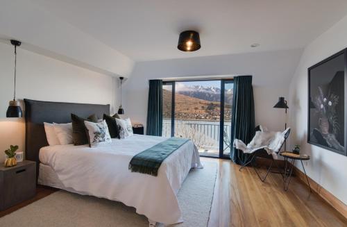 a bedroom with a bed and a large window at Panorama House by Sotheby's Luxury Rental Homes in Queenstown