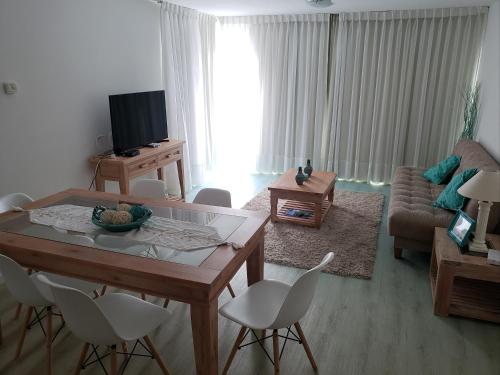 a living room with a table and white chairs at Edificio Paquebot, en Peninsula, con vista al mar in Punta del Este