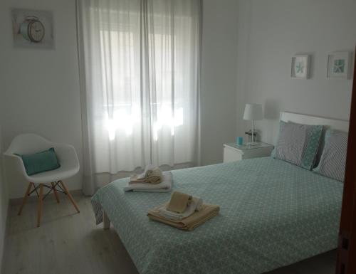 een slaapkamer met een bed met twee handdoeken erop bij Peniche4you in Peniche