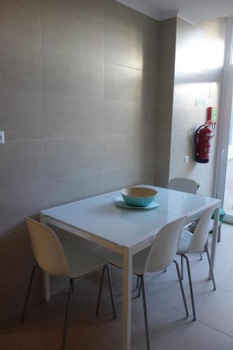 a white table with chairs and a bowl on it at Peniche4you in Peniche