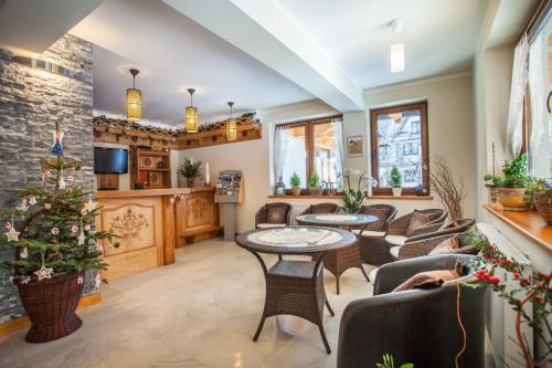 a living room with tables and chairs and a christmas tree at Willa Ryś in Zakopane