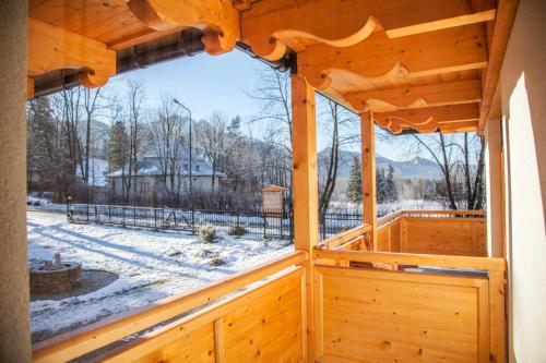 a view from the inside of a wooden house with a window at Willa Ryś in Zakopane