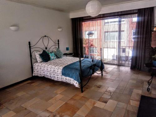 a bedroom with a bed and a large window at Harmony House in Antwerp