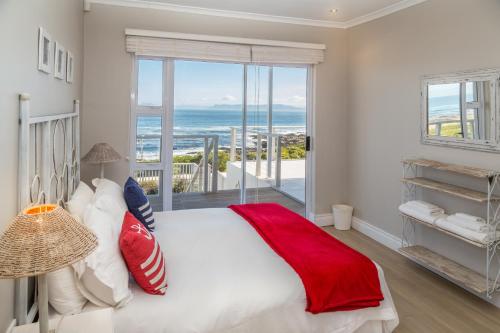 a bedroom with a large bed with a view of the ocean at Ons C-Huis - Gansbaai Seafront Accommodation, back-up power in Gansbaai