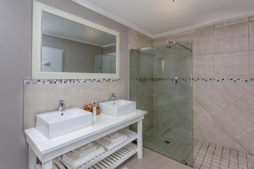 a bathroom with two sinks and a shower at Ons C-Huis - Gansbaai Seafront Accommodation, back-up power in Gansbaai