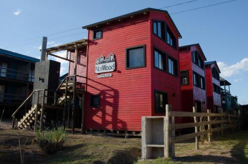 a red building with a sign on the side of it at Norwood Eco Cabañas in Punta Del Diablo