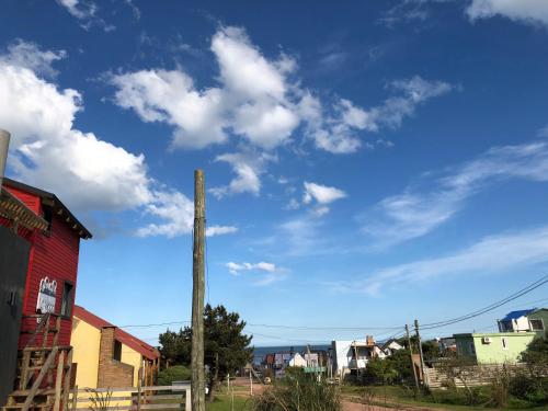 a blue sky with clouds and a telephone pole at Norwood Eco Cabañas in Punta Del Diablo