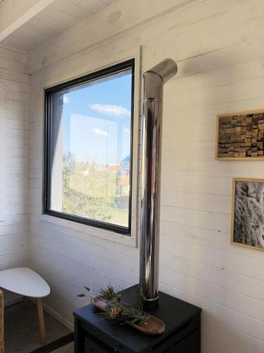 a vase on a table in a room with a window at Norwood Eco Cabañas in Punta Del Diablo