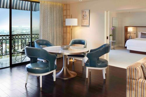 a hotel room with a table and chairs and a bed at The London West Hollywood at Beverly Hills in Los Angeles