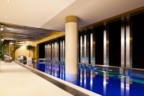 a swimming pool in a building with a column at The Olsen Melbourne Art Series in Melbourne