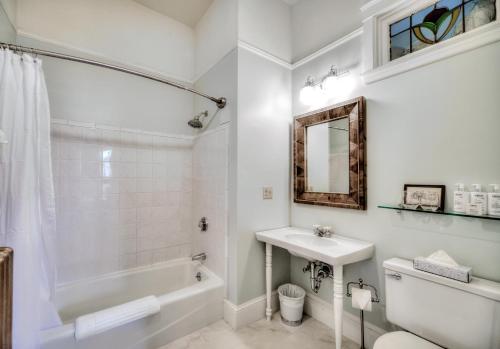 a white bathroom with a tub and a sink at The Water Street Inn in Kittery