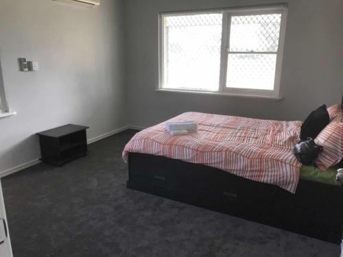 a bedroom with a bed and a window at Maddington House Unit A in Perth