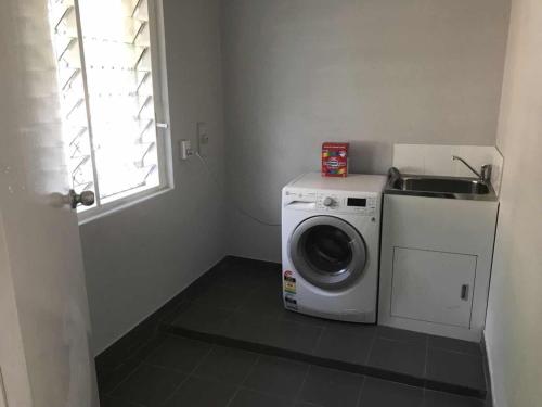 a laundry room with a washing machine and a sink at Maddington House Unit A in Perth