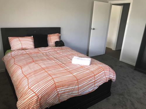 una habitación de hotel con una cama con un libro encima en Maddington House Unit A, en Perth