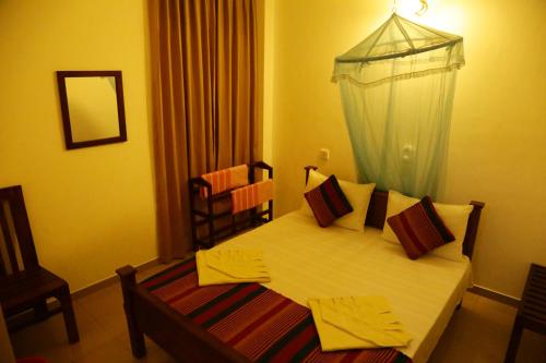 a small bedroom with a bed with a canopy at Vishmee Holiday Inn in Embilipitiya