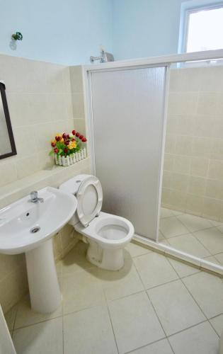 a bathroom with a toilet and a sink and a shower at Sandakan Puteri Indah House in Sandakan