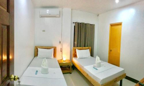 dwa łóżka w małym pokoju z sidx sidx sidx sidx w obiekcie Bangles Homestay w mieście Coron