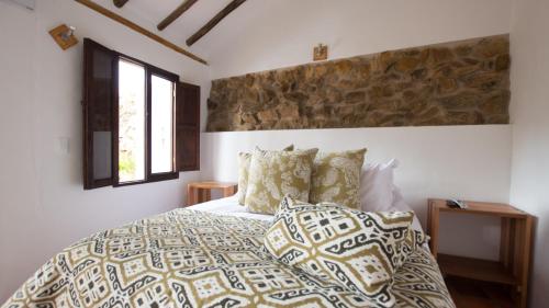a bedroom with a large bed with pillows at Casa Tzabar in Villa de Leyva