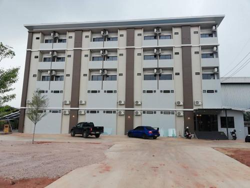 a large building with a car parked in front of it at Sands Place Apartment and Hotel in Samut Sakhon