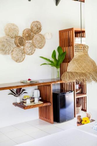 a kitchen with a microwave and a shelf with plates at Aore Island Resort in Luganville