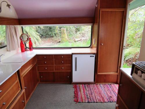 a kitchen with a refrigerator and a window at Greenstone Retreat in Kumara