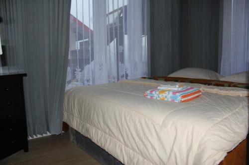 a bed with towels on it with a window at Bromo Otix Guest House in Bromo