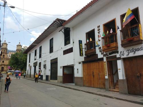 ein Gebäude auf einer Straße mit Leuten, die die Straße hinuntergehen in der Unterkunft Hotel Agualuna in San Gil