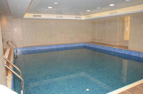 a large swimming pool in a room with blue tiles at Continental Inn Hotel Al Farwaniya in Kuwait
