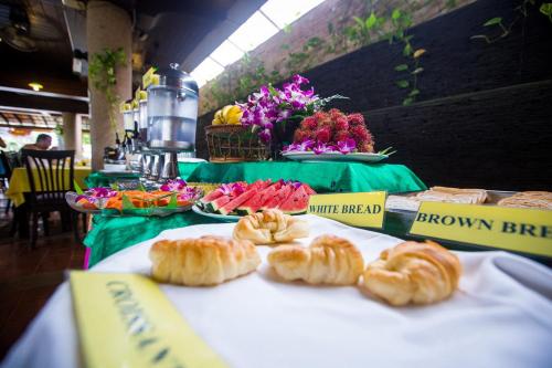 een tafel met croissants en andere zoete deegwaren. bij Kata Poolside Resort SHA Extra Plus in Kata Beach
