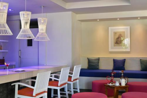 a bar with white chairs and purple walls at Solana Beach Mauritius - Adults Only in Belle Mare