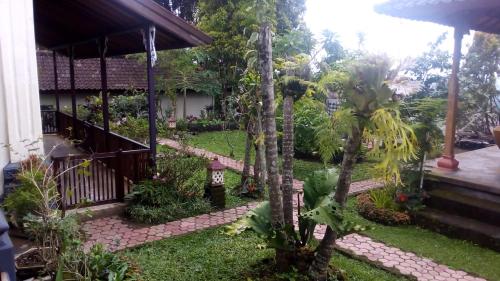 a garden outside a house with palm trees at Guru Ratna in Munduk