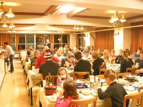 un grupo de personas sentadas en mesas en un restaurante en Villa Alpen, en Yamanouchi