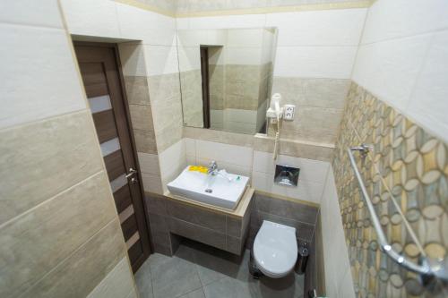 La petite salle de bains est pourvue d'un lavabo et d'un miroir. dans l'établissement Motel Uyut, à Krutinka