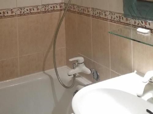 高雄的住宿－儂來旅館，浴室设有卫生间和一个带软管的浴缸。