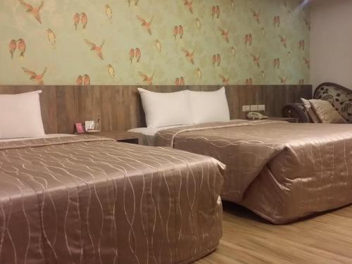twee bedden naast elkaar in een kamer bij Non Lai Inn in Kaohsiung
