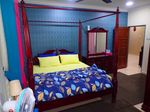 a bedroom with a canopy bed and a mirror at RizQin Homestay Bachok in Bachok