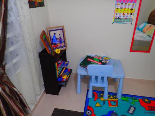 a childs room with a table and a stool at RizQin Homestay Bachok in Bachok