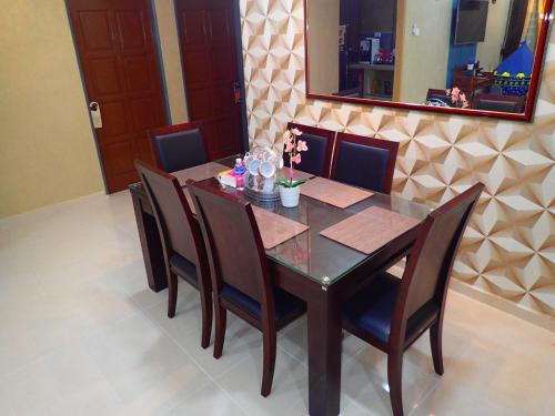 a dining room table with chairs and a mirror at RizQin Homestay Bachok in Bachok