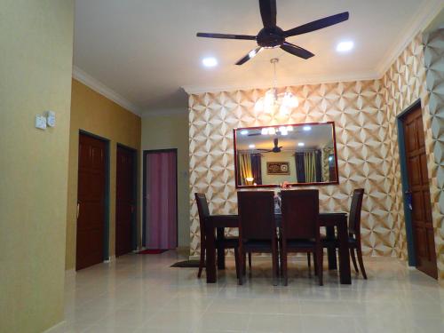 a dining room with a table and a ceiling fan at RizQin Homestay Bachok in Bachok