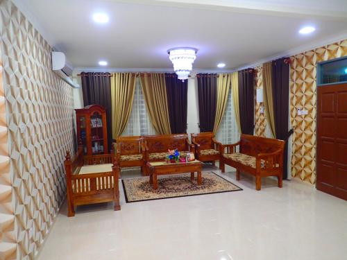 a living room with three chairs and a table at RizQin Homestay Bachok in Bachok